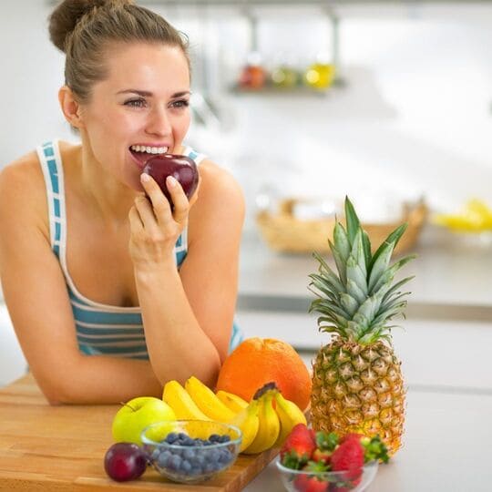 Mulher feliz comendo frutas