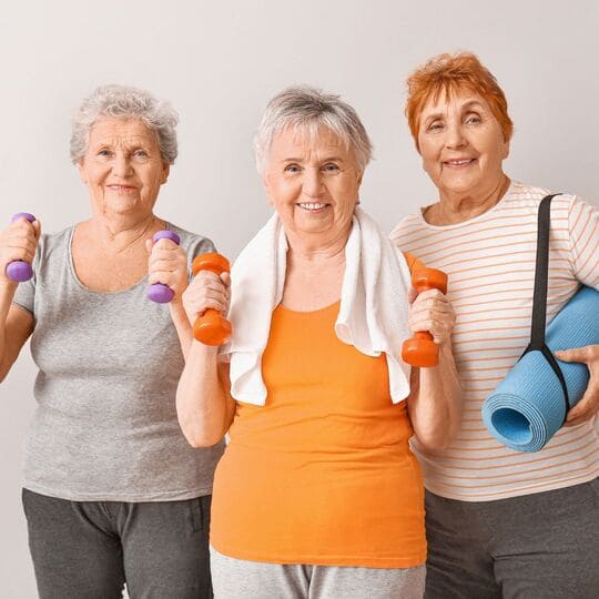 Três mulheres idosas felizes ao fazer exercício